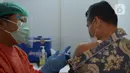 Petugas medis menyuntikan vaksin Covid-19 di lingkungan kerja Kemenkumham, Jumat (12/3/2021). Sebanyak 1000 an lebih vaksin yang di berikan untuk Ditjen Imigrasi Kemenkumham sebagai salah satu upaya dalam rangka pencegahan dan penanggulangan Covid-19. (merdeka.com/Imam Buhori)