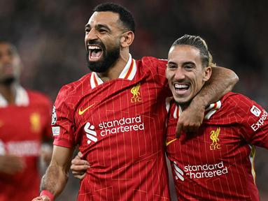 Pemain Liverpool Mohamed Salah (kiri) bersama Kostas Tsimikas merayakan gol pada laga matchday 2 League Phase Liga Champions 2024/2025 melawan Bologna di Anfield Stadium, Inggris pada Rabu 2 Oktober 2024 atau Kamis (3/10/2024) dini hari WIB. (Paul ELLIS/AFP)