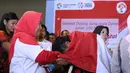 Pelari muda Indonesia, Lalu Muhammad Zohri (kanan) mencium tangan kakak tertuanya saat penyambutan di Terminal 3 Bandara Soetta, Tangerang, Selasa (17/7). Lalu M Zohri meraih emas lari 100m putra U-20 IAAF. (Liputan6.com/Helmi Fithriansyah)