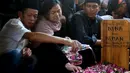 Kerabat menabur bunga di makam presenter sekaligus komedian Nina Carolina atau yang akrab dipanggil Mpok Alpa di Tempat Pemakaman Umum (TPU) Kujaran, Ciganjur, Jakarta Selatan pada Jumat (15/8/2025). (KapanLagi.com/Budy Santoso)