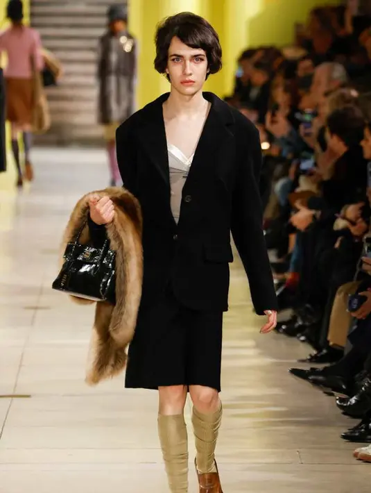 Detail feminin seperti bros, gelang, kalung, serta cape dan stole berbulu menjadi simbol yang berulang, menambah kekuatan pada pakaian yang terinspirasi dari keseharian. [Dok/Miu Miu].