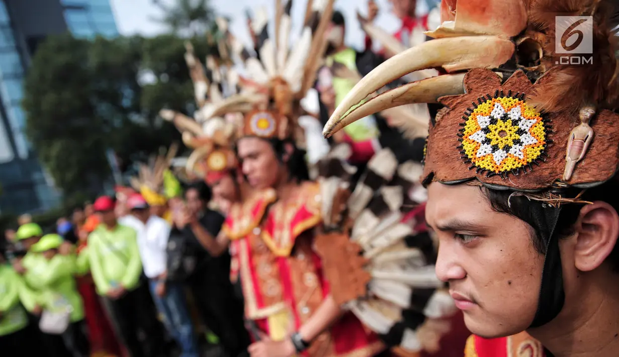 Parade mengenakan pakaian adat dayak dan banjar meramaikan Car Free Day (CFD) di kawasan Sudirman, Jakarta, Minggu (29/10). Kegiatan ini merupakan bentuk kecintaan warga Tabalong, Kalimantan Selatan yang berada di perantauan. (Liputan6.com/Faizal Fanani)