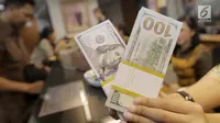 Teller menghitung mata uang dolar di penukaran uang di Jakarta, Jumat (20/4). Nilai tukar rupiah terhadap dolar Amerika Serikat (AS) mengalami pelemahan. (Liputan6.com/Angga Yuniar)