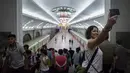 Foto pada 23 Juli 2017 terlihat turis berswafoto ketika mengunjungi sebuah stasiun kereta bawah tanah di Pyongyang, Korea Utara.  (Ed JONES/AFP)