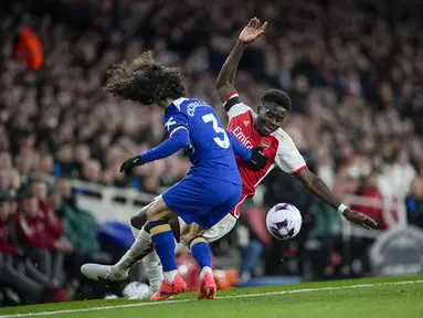 Penyerang Arsenal Bukayo Saka berebut bola dengan bek Chelsea Marc Cucurella dalam duel tunda pekan ke-29 Premier League 2023/2024 di Emirates Stadium, Rabu (24/4/2024) dini hari WIB. (AP Photo/Kin Cheung)