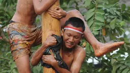 Sejumlah peserta berjibaku lumpur dan oli mengikuti lomba panjat pinang di Perumahan Griya Pamulang 2, Tangerang Selatan, Jumat (17/8). Lomba yang diselengarakan oleh Bina Remaja ini dalam rangka memeriahkan HUT Ke-73 RI. (Merdeka.com/Dwi narwoko)