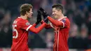 Pemain Bayern Munchen, Robert Lewandowski berselebrasi dengan Thomas Mueller usai mencetak gol ke gawang Besiktas pada pertandingan pertama babak 16 besar Liga Champions di Allianz Arena, Selasa (20/2). Bayern menang telak 5-0. (Matthias Balk/dpa via AP)