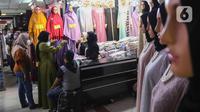 Calon pembeli memilih baju di Pasar Tanah Abang, Jakarta, (28/3/2022). Sepekan menjalang bulan suci Ramadan, Pasar Tanah Abang mulai dipadati pembeli yang hendak berbelanja untuk kebutuhan bulan puasa. (Liputan6.com/Herman Zakharia)