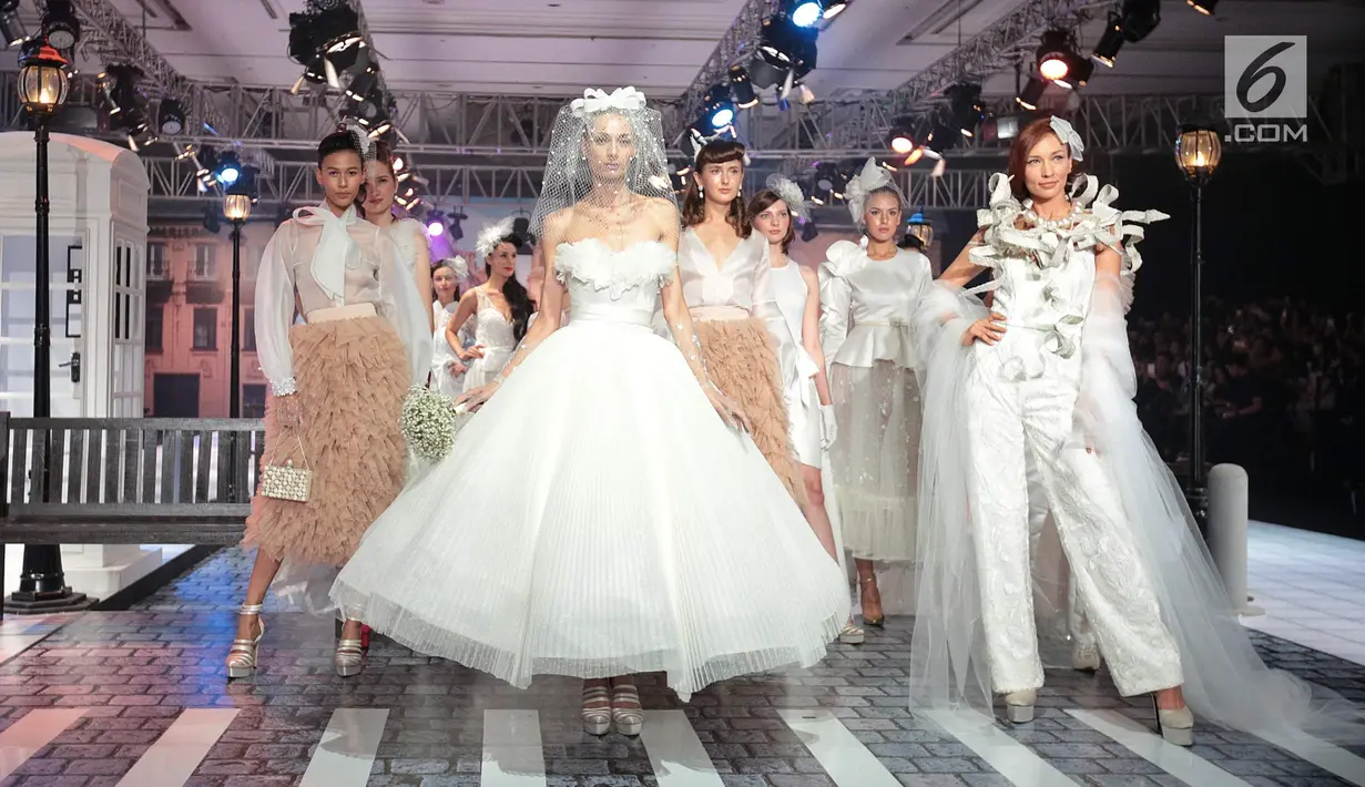 Model mengenakan busana rancangan desainer Fetty Rusli saat tampil dalam fashion show bertema 'Crossing' di Jakarta, Rabu (29/8). Marka bagi pejalan kaki menjadi salah satu inspirasi Fetty dalam koleksinya kali ini. (Liputan6.com/Faizal Fanani)
