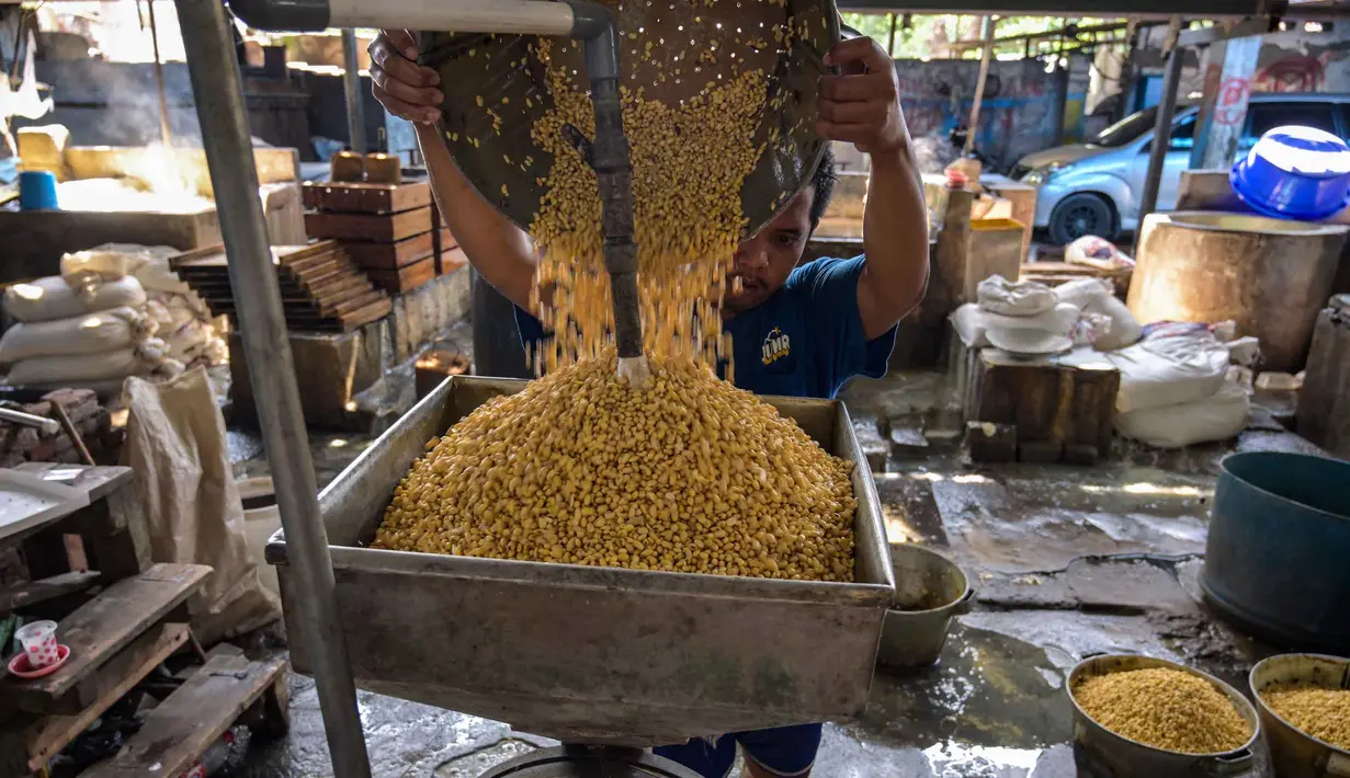 Fluktuasi harga kedelai yang terlalu cepat menyulitkan perajin dalam mengatur produksi dan berpotensi memicu keluhan konsumen. Tampak dalam foto, seorang pekerja membilas kedelai di pabrik tahu, Surabaya, Jawa Timur pada Kamis 5 Februari 2026. (JUNI KRISWANTO/AFP)