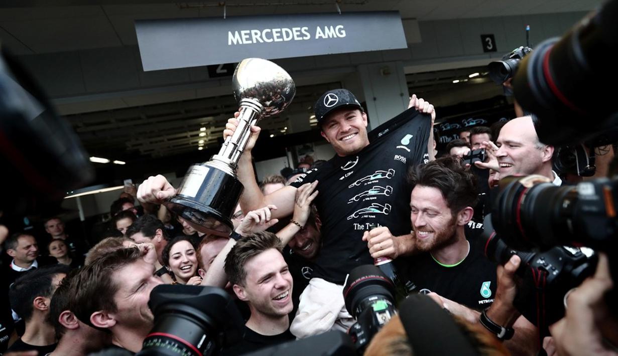 Pebalap Mercedes, Nico Rosberg, merayakan kemenangan bersama kru Mercedes pada balapan F1 GP Jepang di Sirkuit Suzuka, Minggu (9/10/2016). (AFP/Behrouz Mehri)