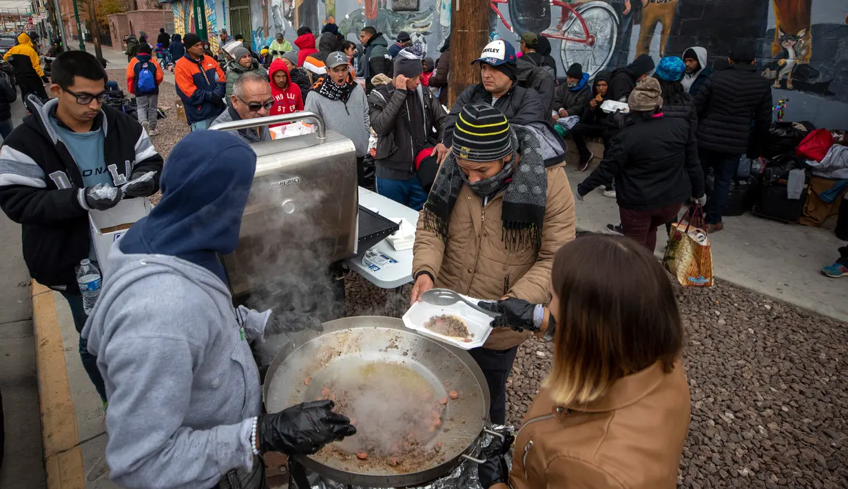 Para imigran disuguhi makanan hangat yang disumbangkan warga di El Paso, Texas, Amerika Serikat, 18 Desember 2022. Kota-kota perbatasan Texas bersiap menghadapi lonjakan sebanyak 5.000 imigran baru setiap hari yang melintasi perbatasan AS-Meksiko karena pembatasan imigrasi era pandemi berakhir minggu ini. (AP Photo/Andres Leighton)
