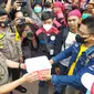 Buruh di Jatim menyerahkan uang koin ke perwakilan Pemprov Jatim. (Dian Kurniawan/Liputan6.com)