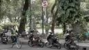 Pengendara sepeda melintas di samping deretan sepeda motor yang terparkir di sekitar Taman Suropati, Jakarta, Selasa (28/8). Meski terpampang rambu larangan parkir dan berhenti, pengendara tetap parkir di sekitar taman. (Liputan6.com/Immanuel Antonius)