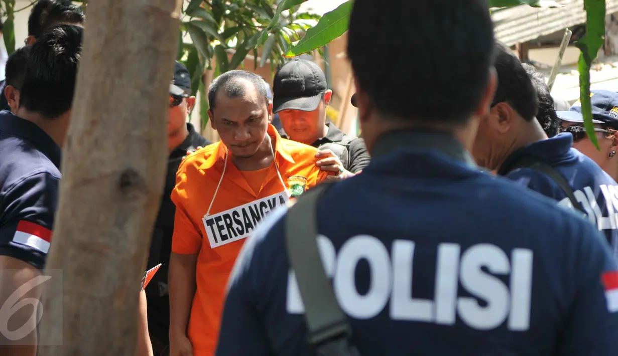 Tersangka Agus Dermawan saat melakukan reka ulang pembunuhan bocah di dalam kardus, Jakarta, Selasa (20/10/2015). Proses rekonstruksi pembunuhan bocah dalam kardus  menjadi tontonan warga sekitar. (Liputan6.com/Gempur M Surya)