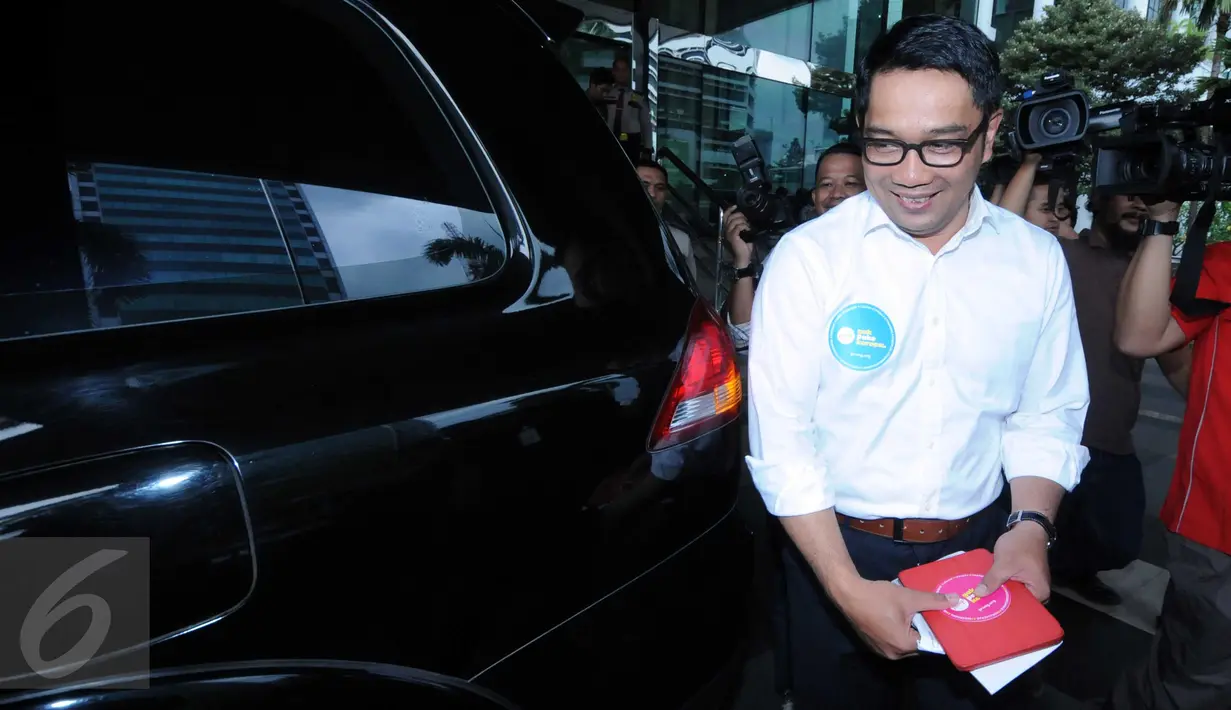 Walikota Bandung Ridwan Kamil bersiap menaiki mobilnya di Gedung KPK, Jakarta, Selasa (24/11). Pria yang akrab Emil ini bermaksud mengkoordinasikan penyelenggaraan Festival Hari Antikorupsi di Bandung pada Desember mendatang. (Liputan6.com/Helmi Afandi)