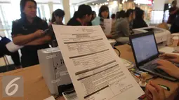 Petugas memperlihatkan formulir pendaftaran pajak salah satu pusat perbelanjaan di Jakarta, Jumat (11/3). Jumlah ini turun 5,4 persen dibanding Januari-Februari 2015 yang mencapai Rp130,8 triliun. (Liputan6.com/Angga Yuniar)