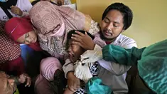 Orangtua, guru, dan polisi mencoba menenangkan seorang siswa saat dia disuntik pada kampanye vaksinasi COVID-19 di sebuah sekolah untuk anak-anak berkebutuhan khusus di Depok, Jawa Barat, Selasa (11/1/2022). Kampanye vaksinasi ini dilakukan oleh Polri. (AP Photo/Dita Alangkara)