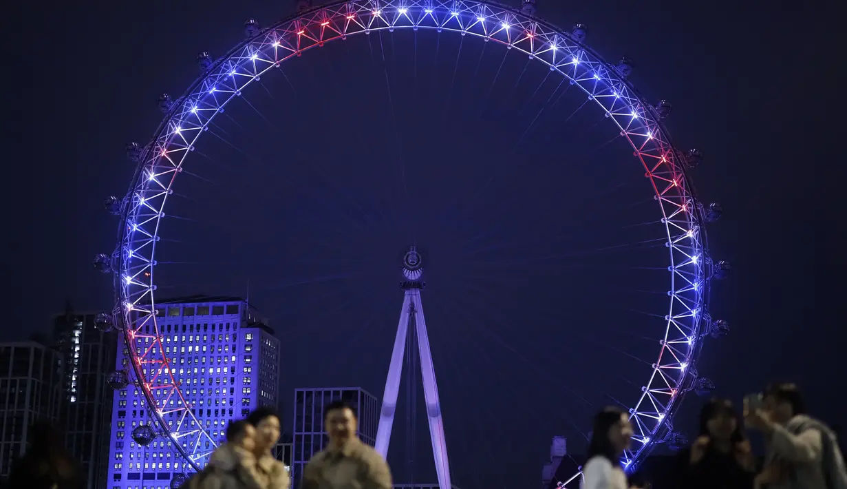 London Eye menyalakan lampu berwarna merah, biru dan putih untuk menghormati kelahiran bayi laki-laki  Pangeran Harry dan Meghan Markle di London, Senin (6/5/2019). London Eye atau Millennium Wheel adalah sebuah roda pengamatan yang terbesar di dunia, memiliki tinggi 135 meter. (Tolga AKMEN/AFP)