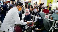 Menteri Perhubungan Budi Karya Sumadi membagikan masker dan penutup wajah kepada para penumpang kereta api hingga pemain musik yang ada di lantai 2 stasiun. (Dok: kemenhub)