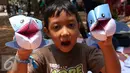 Seorang anak memperlihatkan karya ikan hiu dalam festival laut 2015 di taman Kridaloka,  Senayan, Jakarta, Sabtu (19/9/2015). Festival bertujuan untuk mengenalkan dunia laut Indonesia kepada masyarakat serta untuk menjaganya. (Liputan6.com/Angga Yuniar)
