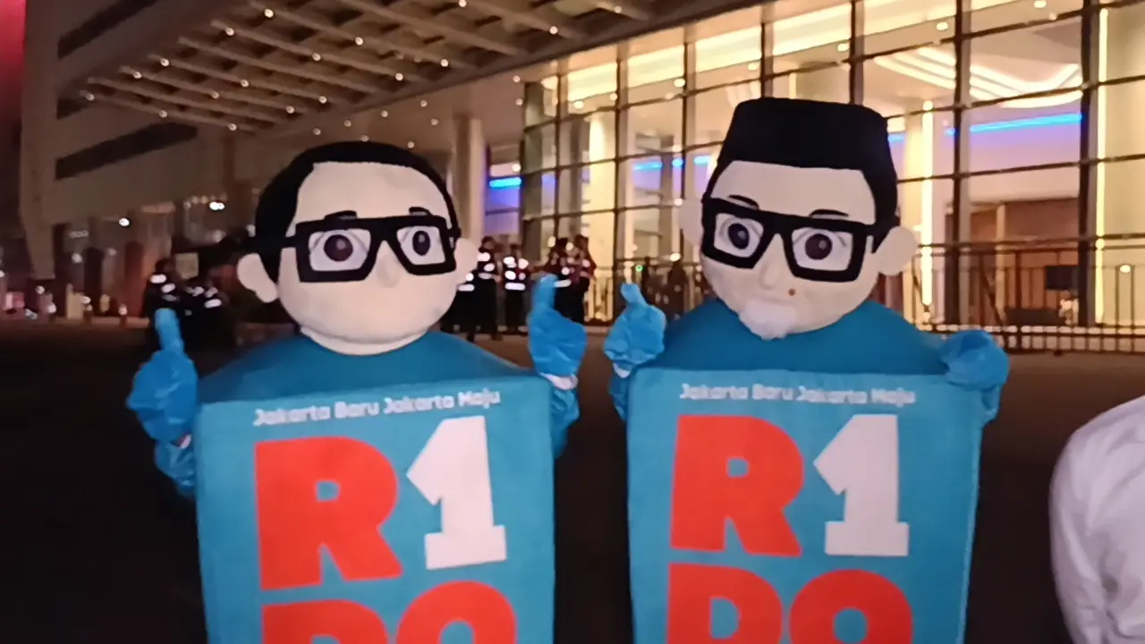 Pendukung Ridwan Kamil-Suswono (RIDO) membawa maskot saat debat perdana berlangsung di Jiexpo, Kemayoran, Jakarta Pusat, Minggu malam (6/10/2024). (Merdeka.com/Nur Habibie)