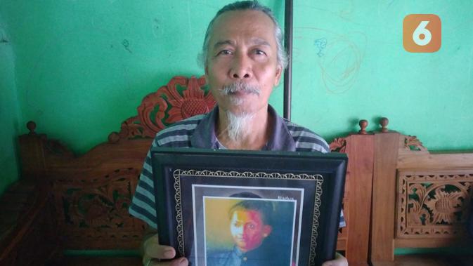 Sugeng Wakimut saat memegangi foto Potjut Meurah Intan di kediamannya Blora kota. (Liputan6.com/Ahmad Adirin)