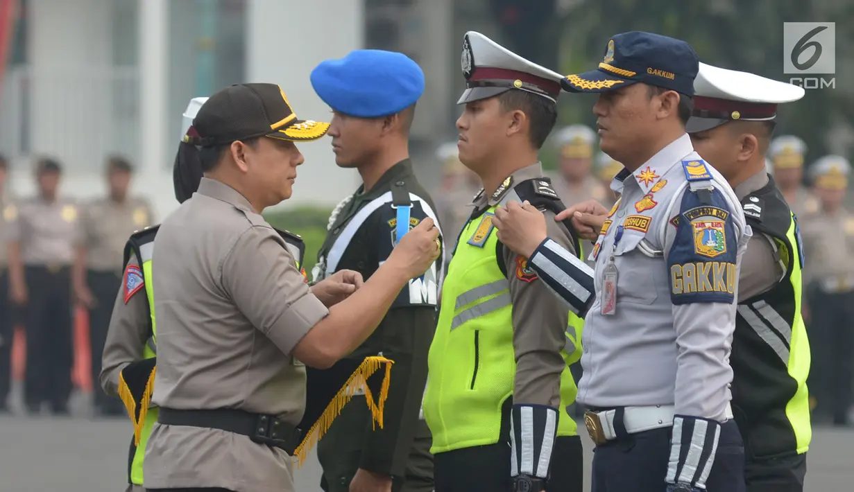 Wakapolda Metro Jaya Brigjen Wahyu Hadiningrat menyematkan pita kepada tiga personel pengamanan dari TNI, Polri dan Dinas Perhubungan saat apel Operasi Patuh Jaya 2019 di Lapangan Promoter Polda Metro Jaya, Jakarta, Kamis (29/8/2019). (merdeka.com/Imam Buhori)