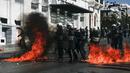 Sejumlah polisi anti huru-hara melawan aksi demonstran yang melemparkan bom api di Athena, Yunani, (12/11/2015). Para Demonstran memprotes langkah-langkah penghematan yang diminta oleh badan pinjaman internasional. (REUTERS/Alkis Konstantinidis)
