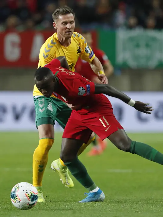 Penyerang Portugal, Bruma berebut bola dengan pemain Lithuania, Saulius Mikoliunas pada pertandingan Grup B Kualifikasi Piala Eropa 2020 di stadion Algarve di luar Faro, Portugal (14/11/2019). Portugal menang besar 6-0 atas Lithuania. (AP Photo/Armando Franca)