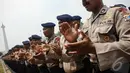 Para Polisi bernyanyi bersama sambil bertepuk tangan untuk memompa semangat saat apel pengamanan pelantikan presiden dan wakil presiden di halaman Monumen Nasional, Jakarta, Jumat (17/10/2014) (Liputan6.com/Faizal Fanani)