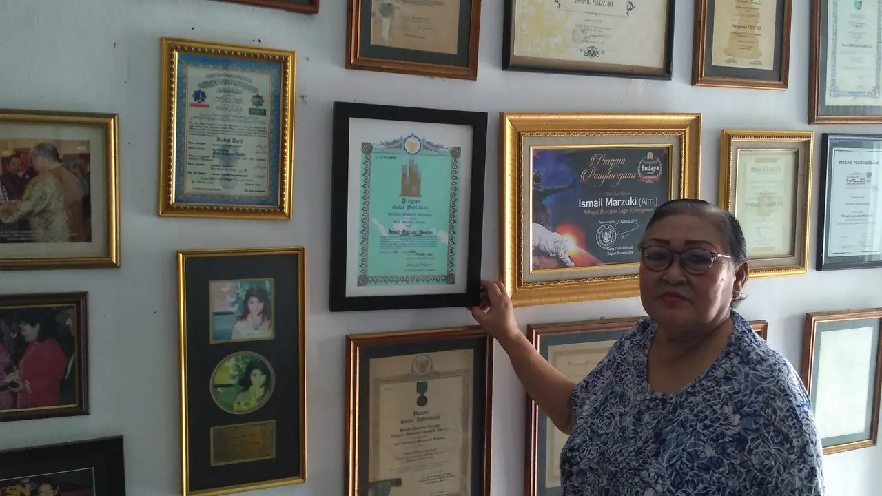 Putri Ismail Marzuki, Rachmi Aziah, menunjukan piagam penghargaan yang diterima ayahnya (Jennar Kiansantang/Liputan6.com)