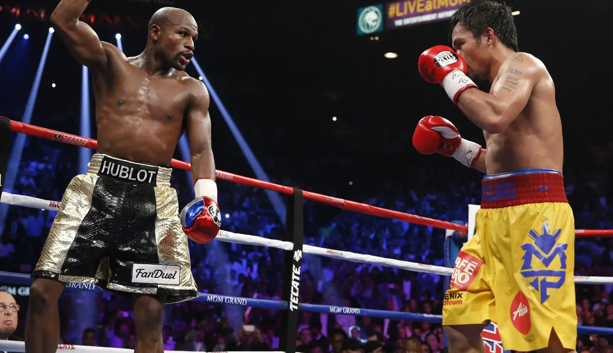 Mayweather Jr. tengah mengambil mengalihkan perhatian Pacquiao dengan mengangkat tangannya. (AP Photo/John Locher)