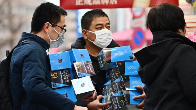 Pelanggan membeli masker dari apotek di daerah Akihabara Tokyo (27/1/2020). Masker dipilih sebagai salah satu tindak pencegahan sederhana dari virus dengan karakteristik mirip SARS tersebut. (AFP Photo/Charly Triballeau)