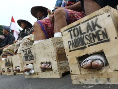 Sejumlah warga Petani Kendeng, Pati, Jawa Tengah menyemen kakinya di depan Istana Negara, Jakarta, Selasa (14 /3). Pada aksi ini di hari kedua ini jumlah petani yang mencor kakinya bertambah menjadi sebelas orang. (Liputan6.com/Helmi Afandi)