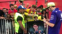 Pebalap Yamaha, Valentino Rossi, memberikan tanda tangan kepada fans di sela-sela perhelatan MotoGP Argentina, Jumat (6/4/2018). (Twitter/Yamaha MotoGP)