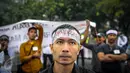 Seorang massa dari Asosiasi Driver Online (ADO) mengenakan ikat kepala di depan Istana, Jakarta, Senin (19/9). Mereka menolak diberlakukannya ujian kendaraan bermotor (KIR) menggunakan SIM A UMUM per 1 Oktober 2016. (Liputan6.com/Faizal Fanani)