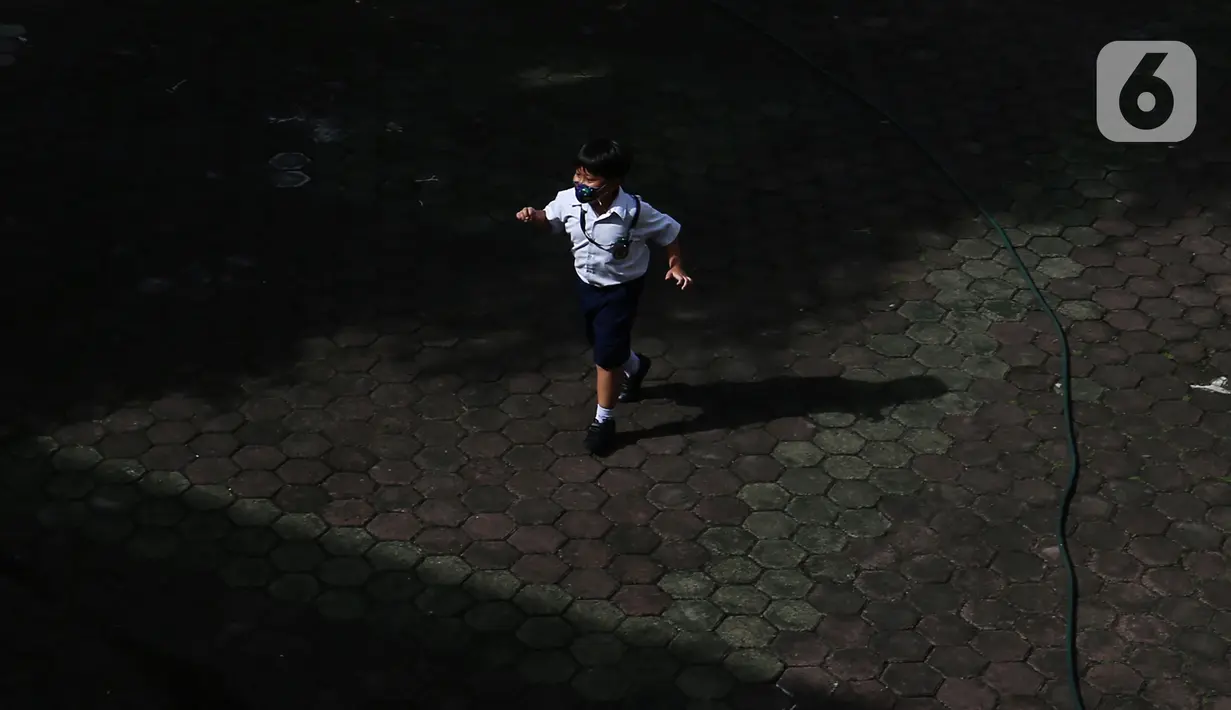 Seorang siswa berjalan di halaman saat pelaksanaan Pembelajaran Tatap Muka (PTM) di SD Pangudi Luhur Jakarta, Rabu (25/5/2022).PPKM level 1 kini diberlakukan untuk wilayah Jakarta dan sekitarnya. Selama PPKM level 1, sekolah di Jabodetabek bisa melangsungkan Pembelajaran Tatap Muka (PTM) 100 persen. (Liputan6.com/Johan Tallo)
