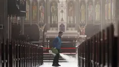 Pekerja memakai masker menyemprotkan disinfektan sebagai tindakan pencegahan virus corona COVID-19 di Katedral Myeongdong di Seoul, Korea Selatan, Rabu, (26/2/2020). Jumlah infeksi corona di Korea Selatan melonjak lagi pada Rabu (26/2). (Lee Ji-eun/Yonhap via AP)