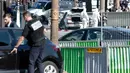 Tim penyelidik forensik memeriksa sebuah mobil usai insiden penyerangan di kawasan Champs Elysees, Paris, Senin (19/6). Kendaraan itu mengeluarkan api usai sengaja menabrak van milik polisi di lokasi wisata terkenal tersebut. (AP Photo/Thibault Camus)