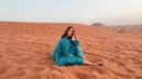Paula Verhoeven juga pernah memamerkan potret dirinya berpose di tengah padang pasir. Ia mengenakan set outfit berwarna hijau yang kontras namun terlihat manis dengan warna pasirnya. [Foto: Instagram/paula_verhoeven]