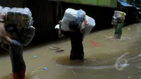 Intensitas curah hujan yang tinggi sejak Minggu (8/2) membuat Sungai Pesanggrahan meluap. Pedagang memindahkan barang dagangannya karena sebagian besar pertokoan dilanda banjir, Pasar Cipulir, Jakarta, Selasa (10/2/2015). (Liputan6.com/Andrian M Tunay)