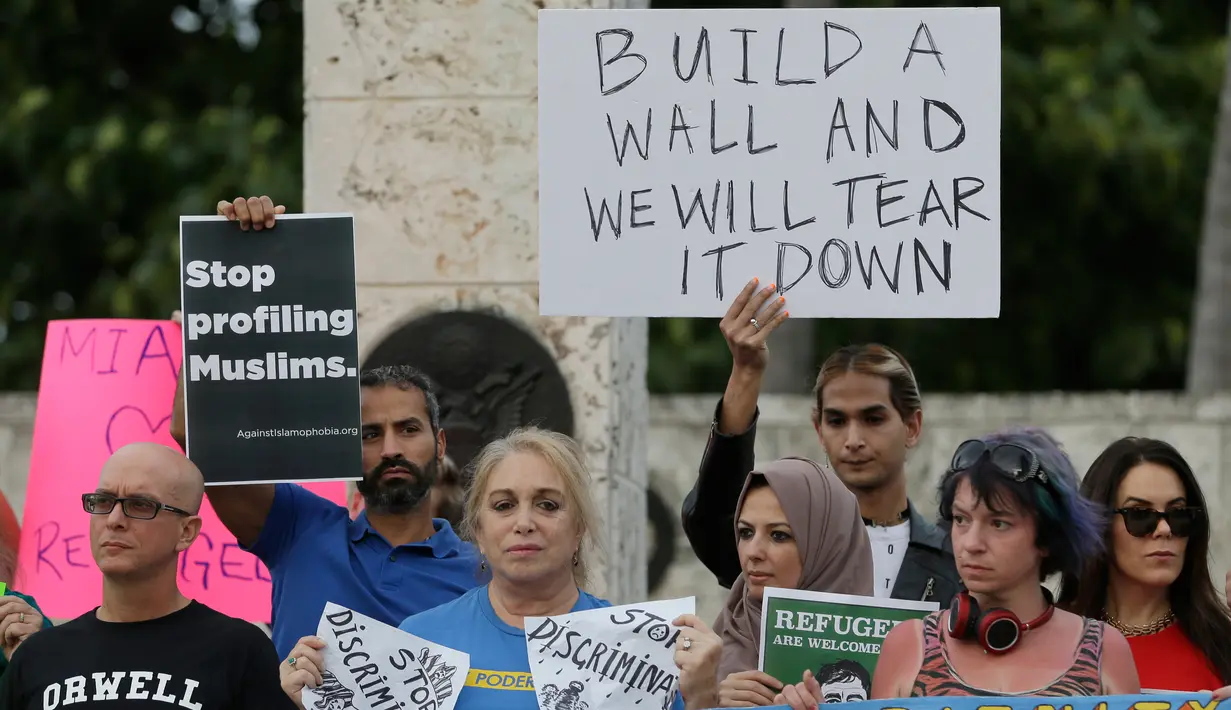 Pengunjuk rasa berdemontrasi di pusat kota Miami, AS, Kamis (26/1). Pengunjuk rasa menolak kebijakan Presiden AS, Donald Trump yang membatasi warga Muslim masuk ke AS. (AP Photo / Alan Diaz)