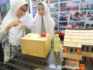 Dua murid SMP mencoba cara kerja dinamo listrik saat kegiatan Puspiptek Innovation Festival (PIF) 2018 di kawasan Puspiptek, Setu, Tangerang Selatan, kamis (27/9). PIF 2018 berlangsung hingga 30 September. (Merdeka.com/Arie Basuki)