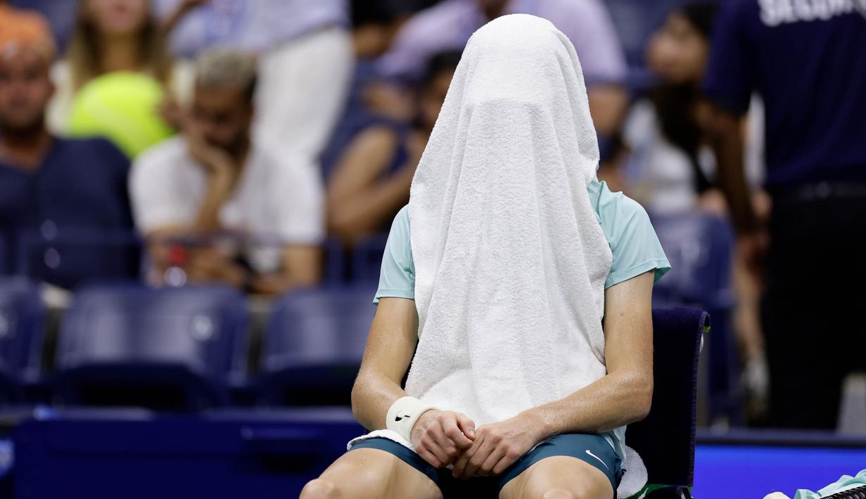 Petenis Italia Jannik Sinner menutupi wajahnya dengan handuk saat pertandingan putaran keempat melawan Alexander Zverev (Jerman) pada kejuaraan tenis AS Terbuka, Senin, 4 September 2023, di New York. (AP Photo/Adam Hunger)