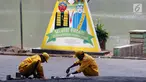 Petugas melakukan perbaikan jalan masuk Setu Babakan, Jakarta, Jumat (14/7). Setu Babakan akan menjadi lokasi pelaksanaan Lebaran Betawi 2017 yang akan digelar pada 21 - 23 Juli 2017. (Liputan6.com/Helmi Fithriansyah)