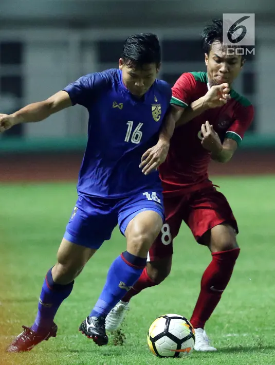 Pemain tengah Timnas Indonesia U-23, M Hargianto (kanan) menahan pergerakan pemain Thailand U-23, Phitiwat Sookjitthammakul pada laga persahabatan di Stadion Pakansari, Kab Bogor, Minggu (3/6). Laga berakhir imbang 0-0. (Liputan6.com/Helmi Fithriansyah)