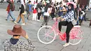 Seorang remaja berpose diatas sepeda kuno di Kota Tua, Jakarta, Minggu (8/5).Dengan latar bangunan tua di kawasan tersebut menjadikan banyak remaja yang mengabadikan gambar mereka. (Liputan6.com/Imma nuel Antonius)