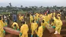 Sejumlah relawan saat memakamkan massal korban banjir dan tanah longsor di sebuah pemakaman di Sierra Leone, Freetown, (17/8). Pemerintah setempat telah mengubur 350 orang yang tewas akibat musibah tersebut. (AP Photo/Manika Kamara)