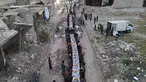 Pemandangan udara menunjukkan warga Suriah duduk di tengah-tengah bangunan yang rusak untuk berbuka puasa di Tadef, dekat kota perbatasan al-Bab, yang dikendalikan oleh pemberontak yang didukung Turki di Suriah di pedesaan timur provinsi Aleppo (18/4/2022). (AFP/Bakr Alkasem)